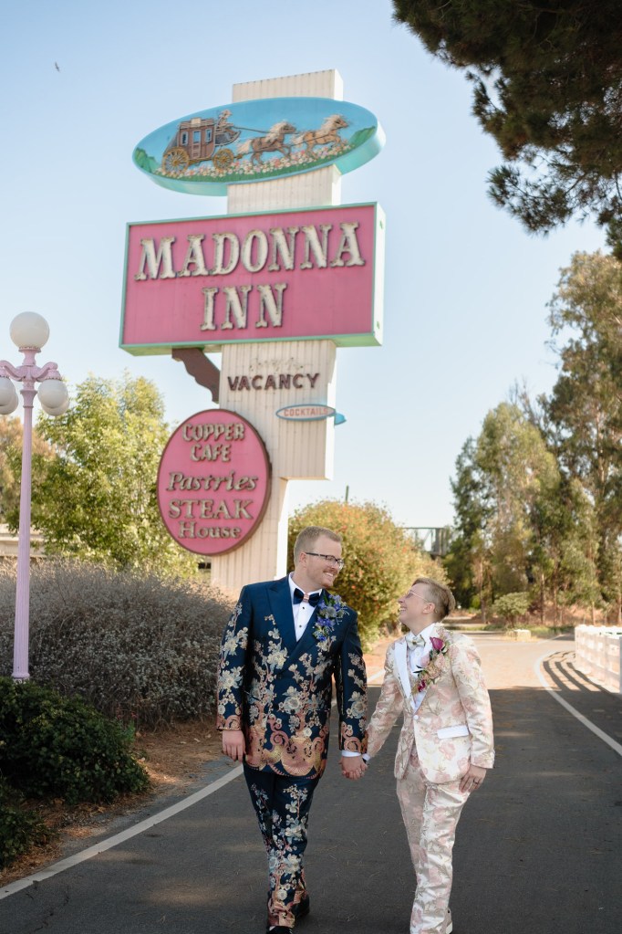 Couple walking in front of iconic Madonna Inn sign photographed during wedding portraits using Fuji X-T30 sample setup.