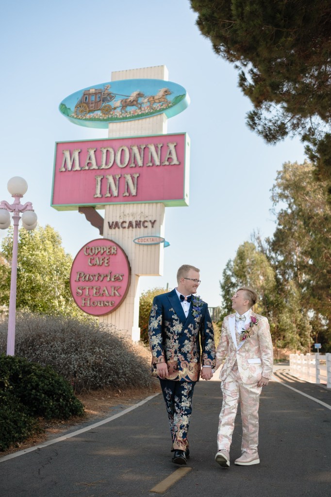 Couple walking in front of iconic Madonna Inn sign photographed during wedding portraits using Fuji X-T30 sample setup.