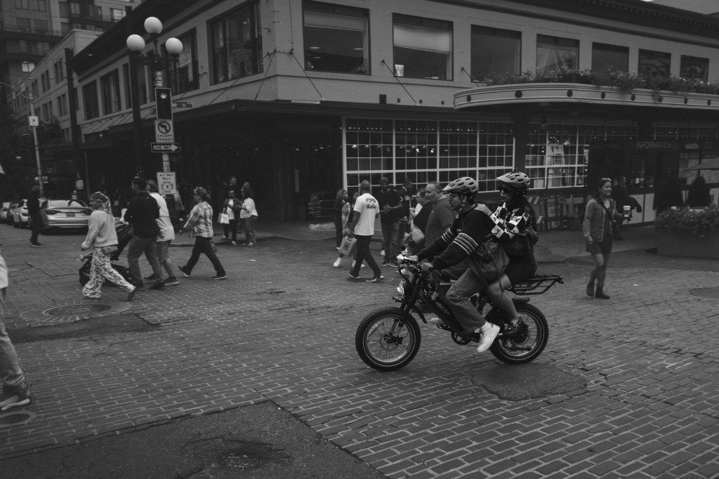 Couple riding a bike through Seattle street near Pike Place Market taken with Fuji XF 18mm f2