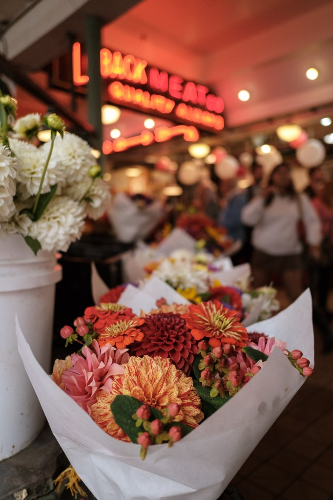 Loback Meat Co neon sign with flowers and natural light at Pike Place Market
